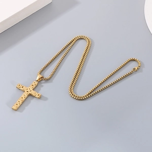 Close-up of golden stainless steel cross pendant with detailed Byzantine chain texture