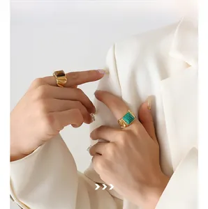 Details von 18K vergoldeten Ringen mit Tigerauge und Malachit an einem weiblichen Model