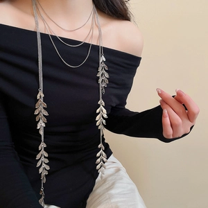 Detail of silver layered leaf tassel necklace showing textured metal pendants and fine chains