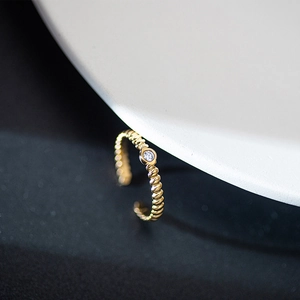 Minimalist gold adjustable stainless steel ring with a round zircon in a twisted band