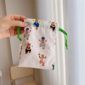 Close-up of drawstring cotton pouch featuring cute bear prints and a green cord tie