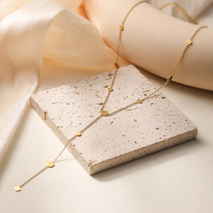 Minimalist gold Y-shaped stainless steel chain necklace with circular charms on silk