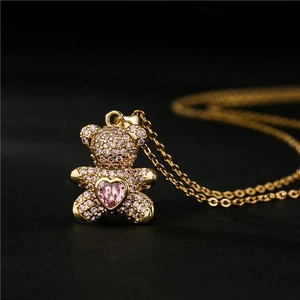 Golden necklace with a micro-pave teddy bear pendant and a pink heart-shaped stone