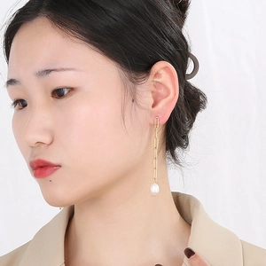 Boucles d'oreilles vintage en plaqué or 18k avec pampilles de perles portées par modèle