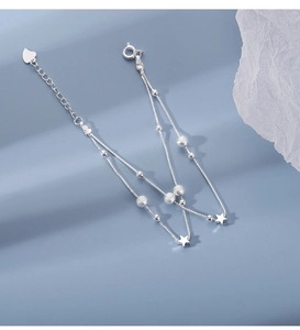 Detail of double-layer silver star bracelet with beads and heart adjustable chain