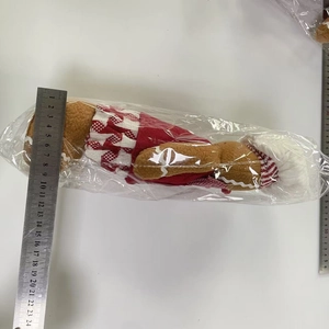 Detailed view of a plush gingerbread man doll being measured with a metal ruler