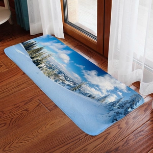 Detailed view of a winter snow scene flannel floor mat on a dark wood floor