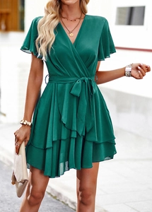Style urbain extérieur d'une robe verte à col en V avec ceinture et ourlet à volants
