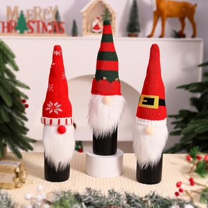 Close-up of three knitted Christmas gnome wine bottle covers with faux fur beards