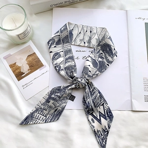 Detail of blue and white silk twilly scarf with floral patterns on minimalist background