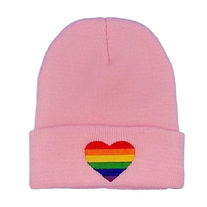 Pink knit beanie hat featuring rainbow heart embroidery and cuffed edge for women