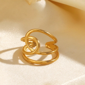 Bague croisée en acier inoxydable plaqué or 18 carats sur fond de soie beige élégante