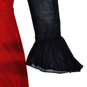 Close-up of red textured fabric with black mesh flare sleeves and ruffle cuffs