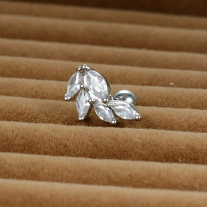 Vue macro d'un piercing d'oreille en forme de feuille avec zircons et fermoir à vis à bille