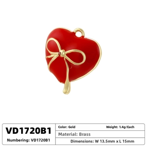 Detail view of heart pendant with red enamel finish and golden bow in brass material