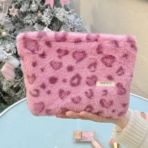 Detailed plush texture of pink heart leopard print cosmetic bag with brand woven label
