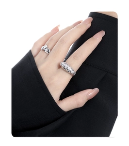 Detailansicht unregelmäßiger silberner Ringe am Finger im minimalistischen Stil