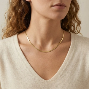 Close-up of gold titanium steel flat snake chain necklace on model neck showing its glossy finish