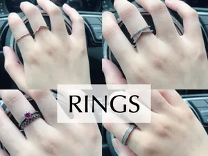 Details von silbernen Ring-Sets mit V-förmigen Pavé-Bändern und einem roten Herz-Ring
