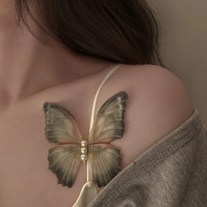 Detailed close-up of a butterfly clip with sheer wings and three elegant white pearls