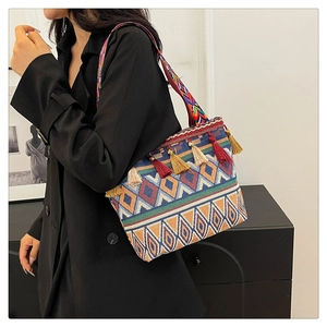 Close-up of ethnic tote bag featuring colorful tassels and woven geometric patterns
