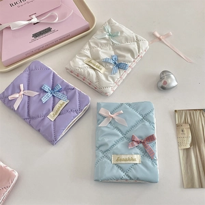 Quilted fabric passport cover with elegant bow detail in soft macaron color palette