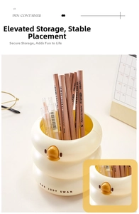 Close-up of cream duck pen holder featuring stacked rings and pencils in a home office set