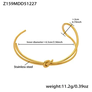 Detail view of gold stainless steel knot bangle with size measurements and weight info