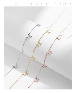 Détail des pendentifs lettres MAMA en finitions argentée, dorée et or rose poli