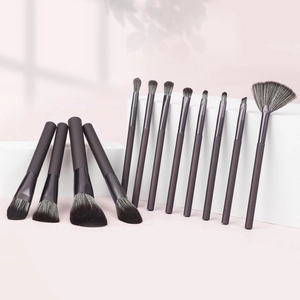 Professional 14-piece makeup brush set with soft grey bristles on geometric stands