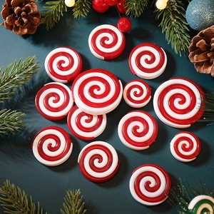 Red and white swirl peppermint candy ornaments in various sizes with Christmas pine background