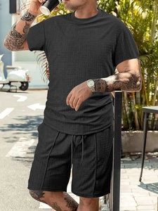 Detail of men's black waffle knit t-shirt and drawstring shorts set with texture