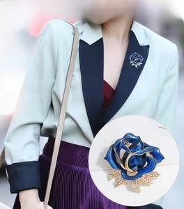 Macro detail of blue enamel rose brooch with sparkling rhinestones and crystal drop
