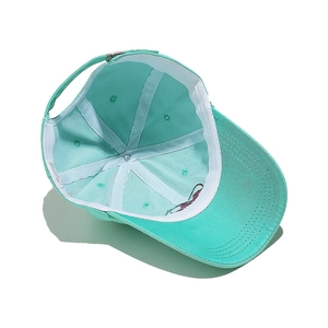 Detail view of mint green cotton baseball cap interior with white sweatband and metal buckle