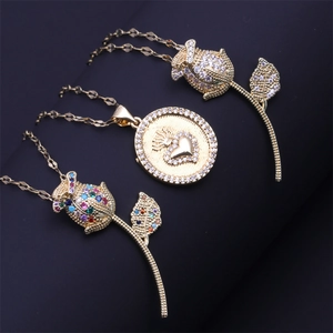 Three gold necklaces featuring rose charms and a crown heart pendant on black background