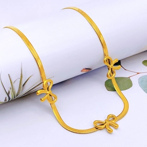 Golden flat snake chain necklace featuring elegant three-dimensional bow accents