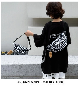 Detail of zebra pattern canvas chest bag for kids with cute plush bear keychain charm