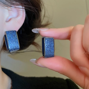 Detailed view of women's vintage U-shaped earrings with micro-paved blue zircons