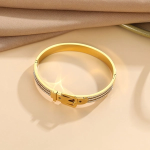 Macro detail of gold-plated belt buckle bracelet featuring sparkling zircon embellishments