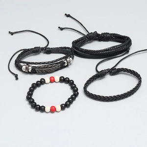 Flat lay of a 4-piece leather bracelet set featuring braided ropes and feather charm