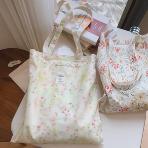 Détail de sacs fourre-tout en coton aux motifs floraux vintage et étiquette tissée
