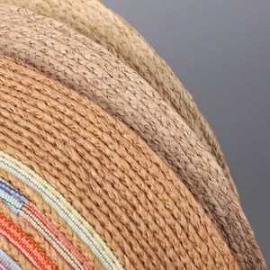 Close-up of woven raffia sun hat texture with colorful striped ribbon stitching details