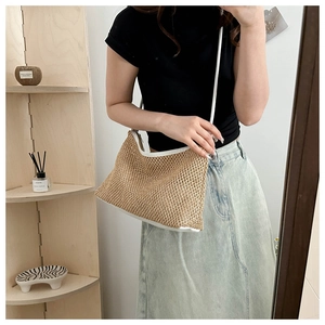 Detail of woven straw tote bag with white leather straps shown in a lifestyle mirror selfie