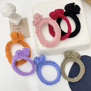 Close-up of colorful handmade crochet hair ties in seven vibrant pastel colors on a tray