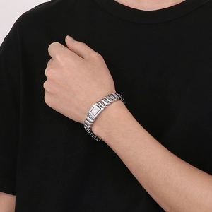 Close-up of silver wavy link dragon bone chain bracelet with square snap buckle on wrist