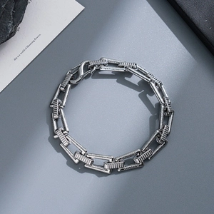 Detailed shot of chunky silver stainless steel chain bracelet with lobster clasp on rock