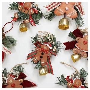 Detail of gingerbread man Christmas ornament with pine branches and golden bell