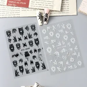 Macro detail of Halloween nail stickers with black spiders and heart web designs