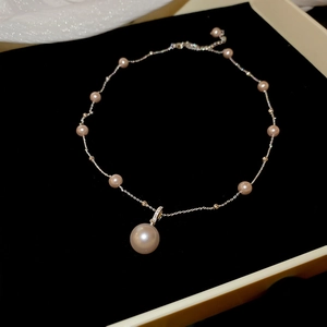 Detailed view of an irregular pearl pendant necklace on a premium black velvet jewelry tray