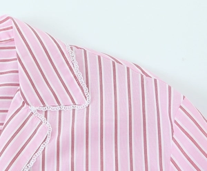 Gros plan sur la texture rayée rose avec une bordure en dentelle blanche sur le décolleté
